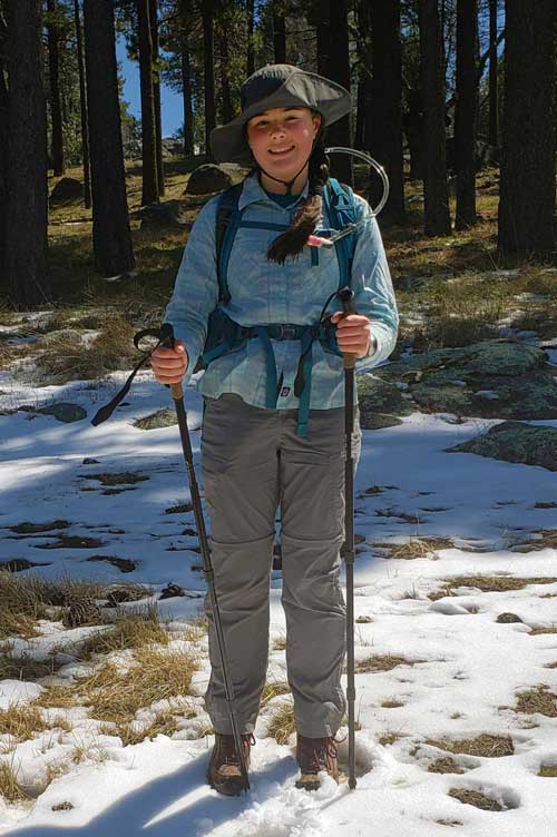 Shannon Deverell, standing on a snowy patch with hiking attire and gears