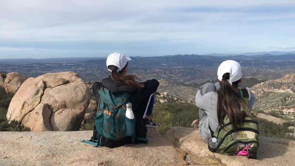 2 hikers sitting down overlooking a magnificent view